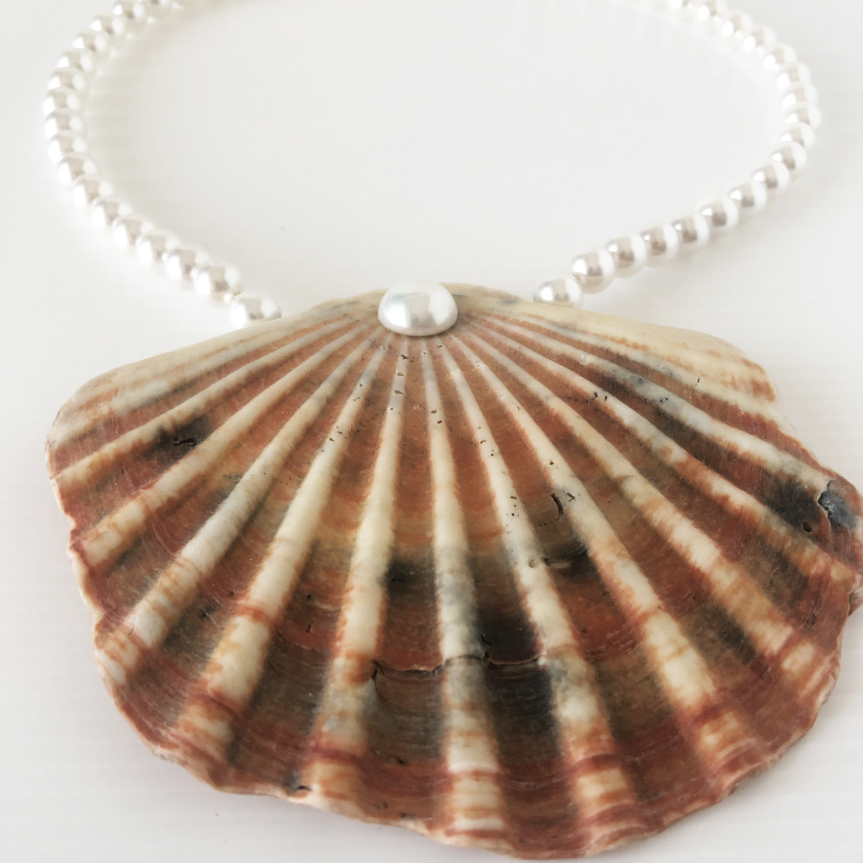 Collana di perle con centrale di conchiglia riccia